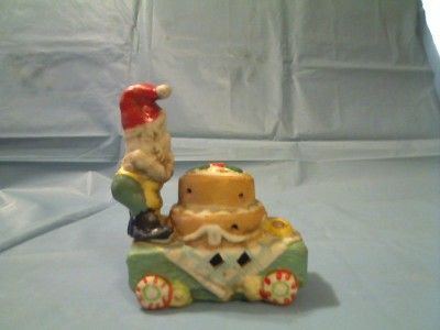 This CERAMIC SANTA OR GNOME ON CAKE CART FIGURINE is in FAIR condition 